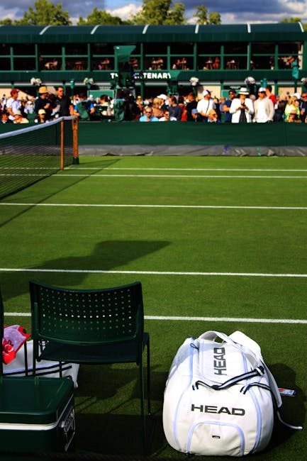 A black and white photograph of a residential hallway taken from a low-angle perspective. The carpeted floor appears clean and well-maintained, with a textured surface visible close up. On either side, white wooden wainscoting runs along the lower part of the walls, which are painted in a light color. Several closed white doors are evenly spaced along the corridor, each with decorative molding. The ceiling features a circular overhead light fixture casting diffuse illumination, creating a bright and hygienic atmosphere. In the background, the hallway extends towards a door at the end. The image showcases a neat, dust-free environment suitable for professional surface cleaning and sanitisation, as provided by Merton Carpet Cleaning, serving the Wimbledon Village area.